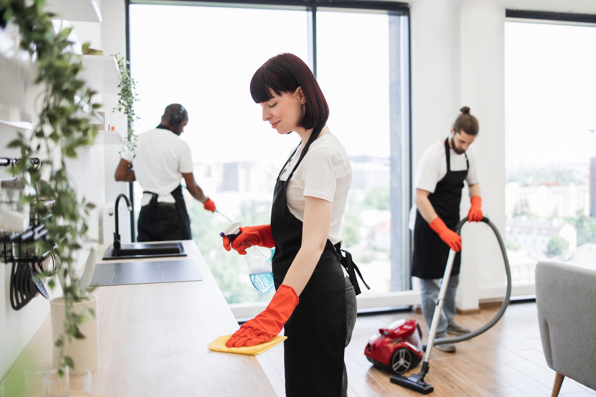 Portrait of Caucasian young woman cleaning on table in kitchen room.
